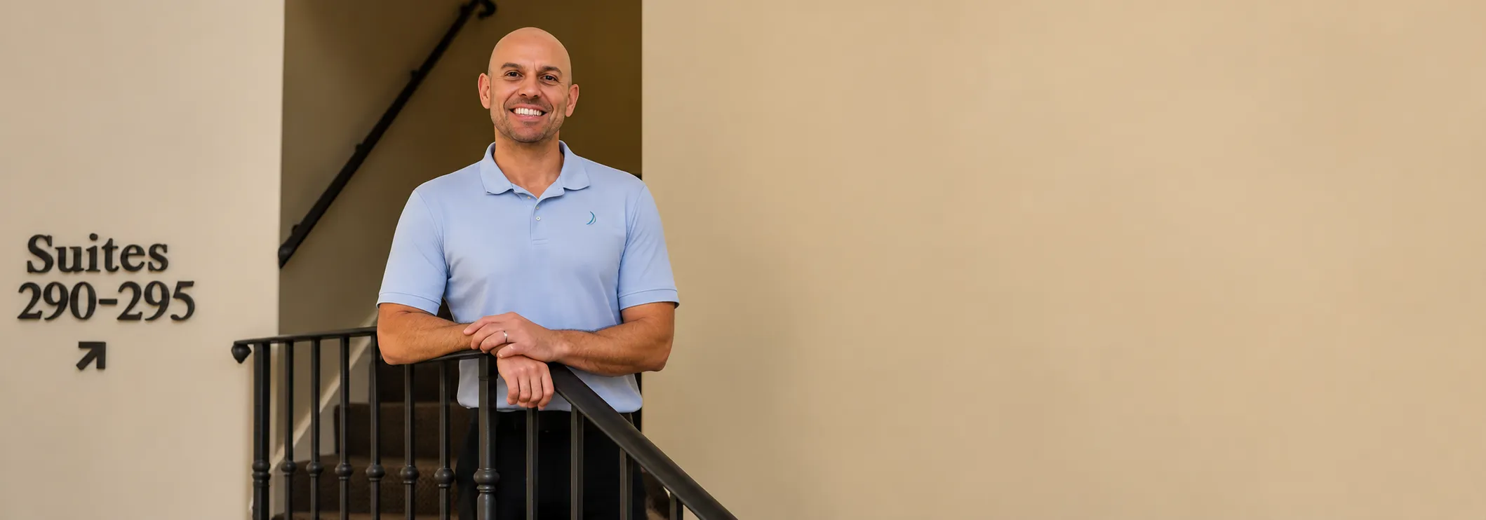 Chiropractor Armen Agacanyan standing at the top of a staircase.