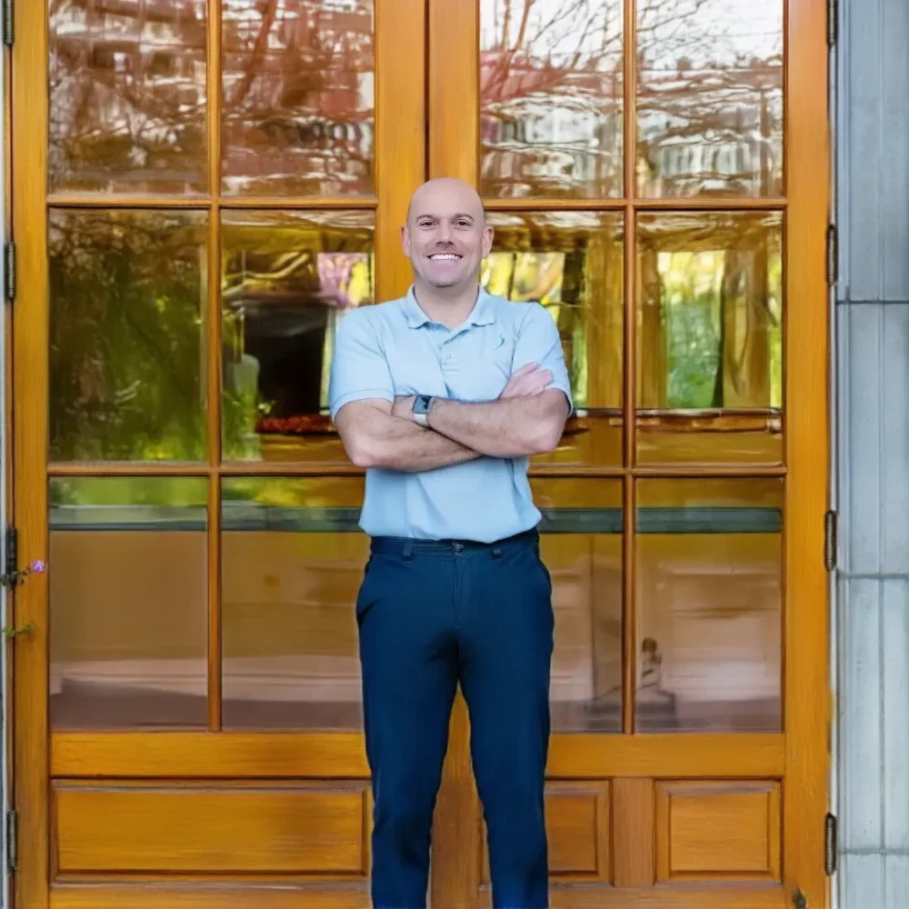 Armen Agacanyan smiling in front of a door.